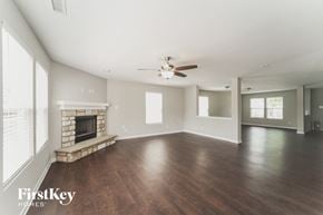 Charlotte house for rent - A spacious room with a fireplace and wooden floors.