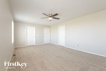 Lochbuie house for rent - a spacious living room with carpet and a ceiling fan
