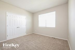 Lochbuie house for rent - a bedroom with carpet and a white door and window