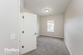Murfreesboro house for rent - a bedroom with a white door and carpeted flooring and a window
