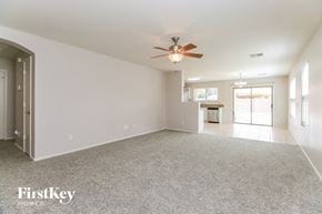 Queen Creek house for rent - an empty living room with a ceiling fan and a kitchen