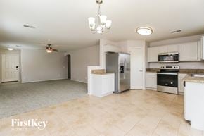 Queen Creek house for rent - a kitchen with white cabinets and stainless steel appliances