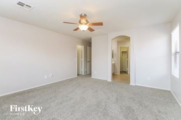 Queen Creek house for rent - a spacious living room with carpet and a ceiling fan