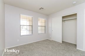 Queen Creek house for rent - a bedroom with a closet and two windows and a door