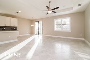 Alva house for rent - an empty kitchen and living room with a ceiling fan