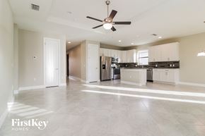 Alva house for rent - an empty kitchen and living room with a ceiling fan