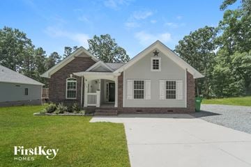 Locust house for rent - a white and brick house with a white sidewalk and grass