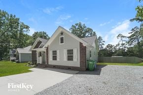 Locust house for rent - a small white house with a gravel driveway and a green yard