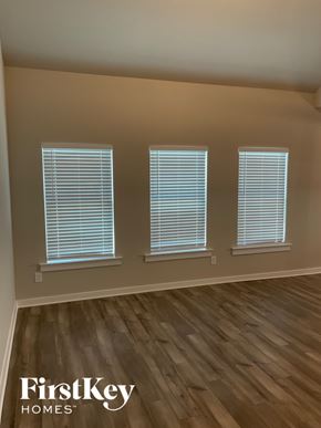 Clanton house for rent - A room with wooden flooring and three windows with blinds.