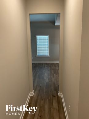 Clanton house for rent - A hallway with wooden floors and a doorway leading to another room.