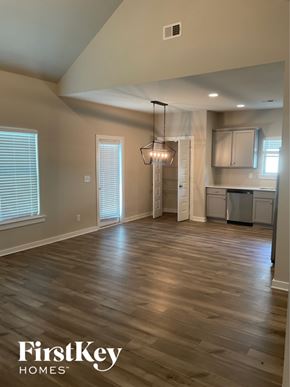 Clanton house for rent - A spacious room with wooden flooring and a chandelier hanging from the ceiling.