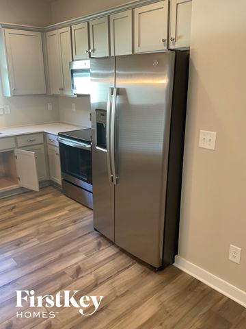 Clanton house for rent - A stainless steel refrigerator in a kitchen with wooden flooring.