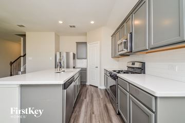 Anna house for rent - a white kitchen with stainless steel appliances and white counter tops