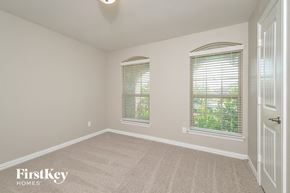 Anna house for rent - a bedroom with a carpeted floor and two windows