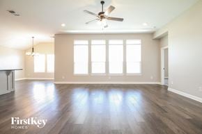 Yukon house for rent - an empty living room with wood floors and a ceiling fan