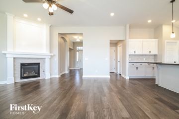 Yukon house for rent - a living room with a fireplace and a kitchen with white cabinets