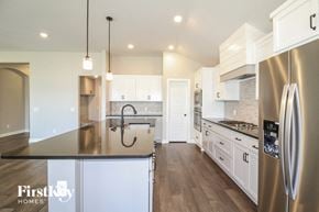 Yukon house for rent - a large kitchen with stainless steel appliances and white cabinets