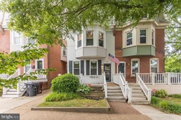 Wilmington house for rent - the front of a red brick house with a porch and a flag