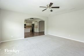 Locust house for rent - an empty living room with white carpet and a ceiling fan