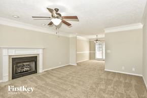Clarksville house for rent - an empty living room with a ceiling fan and a fireplace