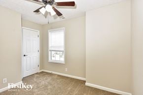 Clarksville house for rent - a bedroom with a ceiling fan and a white door