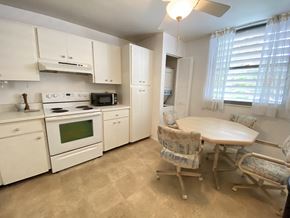 Bradenton house for rent - a kitchen with white appliances and a table and chairs