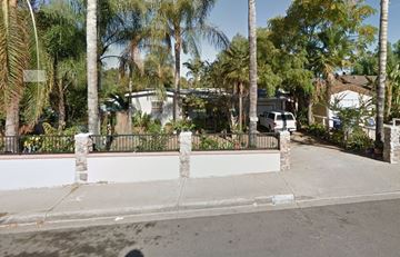 Escondido apartment for rent - a street with a white wall and palm trees