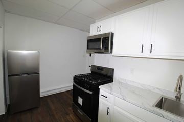 Chester apartment for rent - A kitchen with a black stove top oven and microwave.
