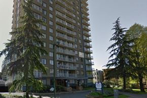 Vancouver apartment for rent - A tall residential building with balconies and a sign in front.