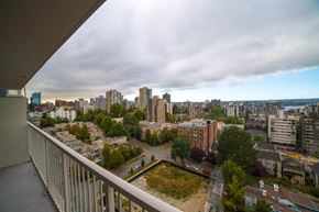 Vancouver apartment for rent - A cityscape viewed from a balcony with buildings and trees in the foreground.