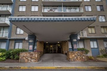 Vancouver apartment for rent - The entrance to a building with a stone pillar on either side.
