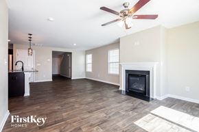 Dallas house for rent - A spacious living room with a fireplace and a ceiling fan.