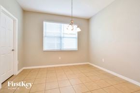 Kissimmee house for rent - a dining room with a large window and a tiled floor