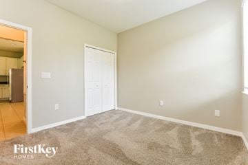 Kissimmee house for rent - a living room with carpet and a door to a kitchen