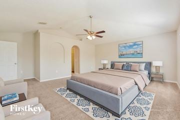 Leesburg house for rent - A bedroom with a large bed and a painting on the wall.