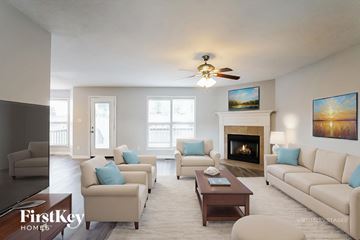 Clarksville house for rent - A living room with a fireplace and a painting on the wall.