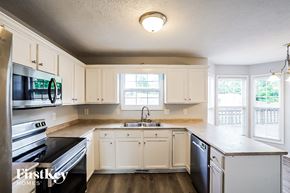 Clarksville house for rent - A kitchen with white cabinets and a black dishwasher.