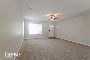 Denver house for rent - A spacious room with a carpeted floor and a ceiling fan.