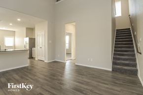 Katy house for rent - A spacious living room with wood flooring and a staircase on the right.