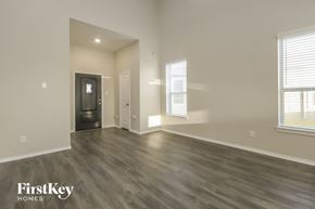 Katy house for rent - A spacious room with wood flooring and a window with blinds.