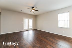 Fort Worth house for rent - the spacious living room with hardwood flooring and a ceiling fan