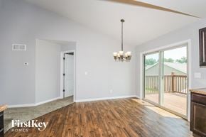Troy house for rent - an empty living room with wood flooring and sliding glass doors to a deck