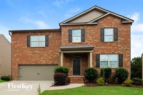 Dallas house for rent - A brick house with a garage door and a sign that says FirstKey Homes.