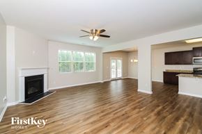 Dallas house for rent - A spacious living room with wood flooring and a fireplace.