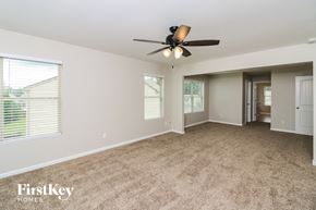 Dallas house for rent - A spacious room with a ceiling fan and carpeted floor.