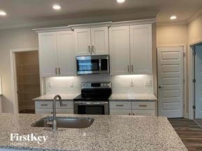 Concord house for rent - an updated kitchen with white cabinets and granite counter tops