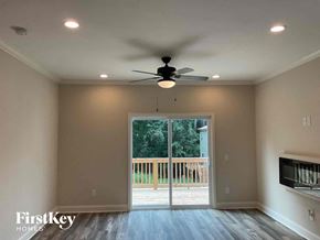 Concord house for rent - an empty living room with a ceiling fan and a door to a deck