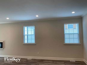 Concord house for rent - a living room with two windows and a wall with a wood floor