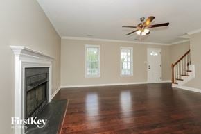 Lexington house for rent - an empty living room with a fireplace and a ceiling fan