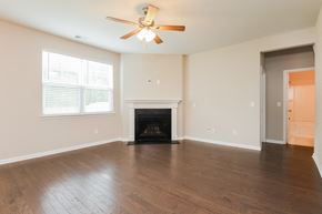 Moncks Corner house for rent - A room with a fireplace and a ceiling fan.